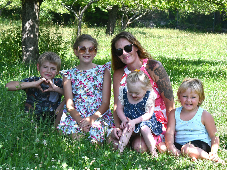 Shannon Sharkazy and her children, from left, Carter, 10; Blake, 11; Mason, 5; and Emerson, 4 spend time in the orchard on their Beach Lake property.